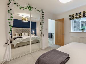 a bedroom with a bed and a mirror at 3 Bed in Barnstaple 87116 in Fremington
