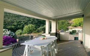 a porch with a white table and chairs on a balcony at Villa Terrazza sul Mare in Budoni