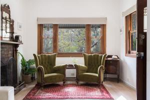 a living room with two chairs and a table at The Old Library in Balnarring Beach