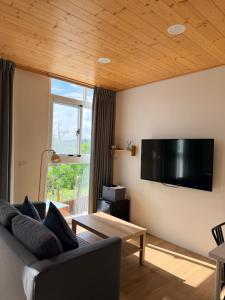 Una sala de estar con un sofá y un televisor en la pared. en 雲山盼盼民宿, en Dongshi
