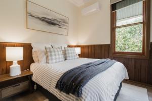 a bedroom with a bed and a window at The Old Library in Balnarring Beach