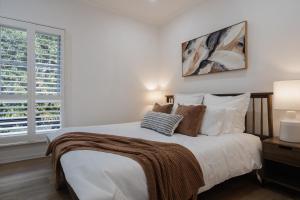 a bedroom with a bed with white sheets and pillows at The Old Library in Balnarring Beach