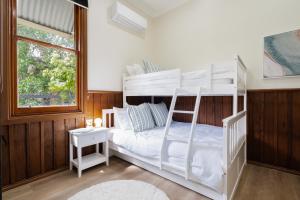a bedroom with a white bunk bed and a window at The Old Library in Balnarring Beach +27 photos