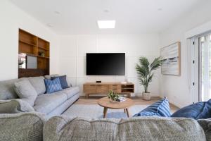a living room with a couch and a tv at The Old Library in Balnarring Beach