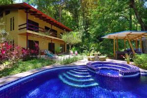 a swimming pool in front of a house at Toucan Villa Family home w Private Pool Garden AC in Quepos