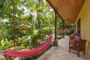 an outdoor patio with a hammock on a house at Toucan Villa Family home w Private Pool Garden AC in Quepos