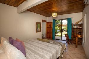a bedroom with a bed and a desk and a window at Toucan Villa Family home w Private Pool Garden AC in Quepos +80 photos