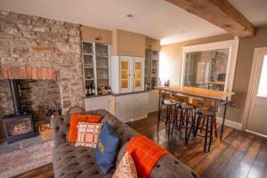 a living room with a couch and a stone wall at The New White Lion in Llandovery