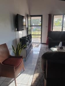 a living room with a couch and a tv and a chair at Jetpoint Bed & Breakfast in Nadi