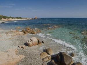 a beach with some rocks and water and the ocean at Casa Pili in San Vito