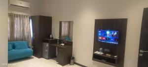 a living room with a blue chair and a television at Shubham Residency Thane in Kālva +6 photos