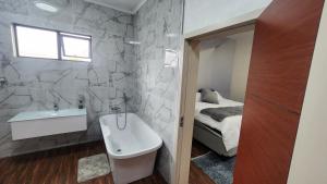 une salle de bain avec un lavabo et des toilettes et un lit dans l'établissement Casa lux boutique guest house, à Newcastle 26 autres photos