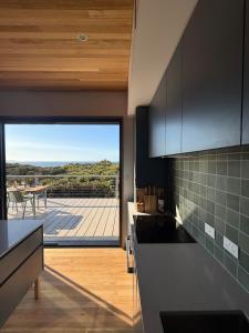 a kitchen with a view of a patio with a table at Sommerhus Danish inspired beach front retreat in Vivonne Bay