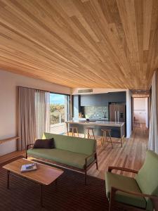 a living room with a green couch and a kitchen at Sommerhus Danish inspired beach front retreat in Vivonne Bay