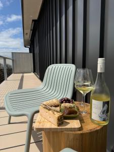 a bottle of wine and a plate of food on a table at Sommerhus Danish inspired beach front retreat in Vivonne Bay +16 photos
