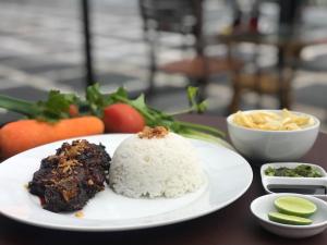 a plate of food with rice and vegetables on a table at @K Hotel in Yogyakarta