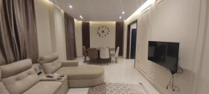 a living room with a couch and a tv in it at White Rose in New cairo +3 photos