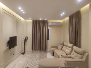 a living room with a couch and a tv at White Rose in New cairo