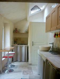 a kitchen with a sink and a table and a counter at Gîte Laure et Henri in Ladoix Serrigny