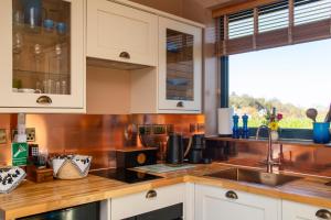 a kitchen with white cabinets and a sink and a window at Enchanted Lodges - Maroc in Ospringe