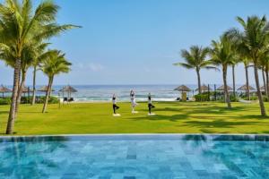 un gruppo di persone che fa yoga in spiaggia di Hoi An Royal Beachfront Resort & Villas a Dien Ban Altre 147 foto