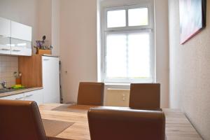 a kitchen with a table with chairs and a window at GUWO Gästewohnung Straupitzstraße 12 in Guben