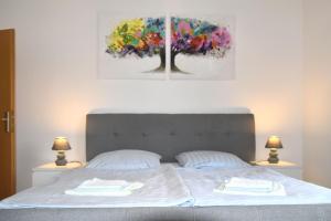 a bedroom with a bed with two paintings on the wall at GUWO Gästewohnung Straupitzstraße 12 in Guben
