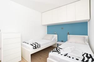 2 Betten in einem Zimmer mit weißen Schränken in der Unterkunft CAPRARIA appartments in historic center, with private parking in Koper