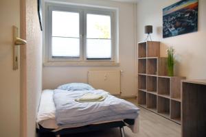 a small room with a bed and a window at GUWO Gästewohnungen Kaltenborner Straße 156 in Kaltenborn