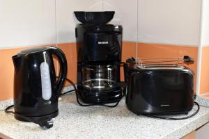 2 tostadoras y una cafetera en una encimera en GUWO Gästewohnung Friedrich-Schiller-Str 27, en Guben 4 fotos más
