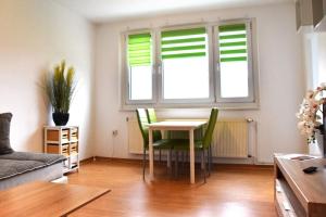 - un salon avec une table et des chaises vertes dans l'établissement GUWO Gästewohnung Platanenstraße 1, à Sprucke
