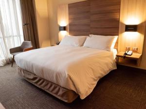 ein großes weißes Bett in einem Hotelzimmer in der Unterkunft Hotel Costanera Concepcion in Concepción