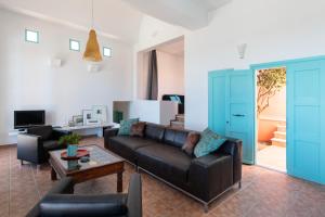 a living room with a couch and a table at Villa Malia, Eco-Chic, Tranquility, Sea Views & Luxury Cycladic Island Escape in Tálanda