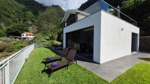 ein weißes Haus mit zwei Stühlen auf einem Balkon in der Unterkunft Blue Horizon Luxury Villa in Senhora do Rosário