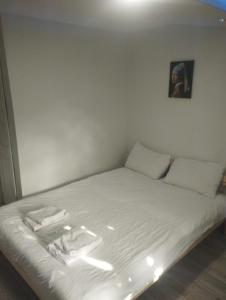 een bed met witte lakens en een schilderij aan de muur bij Şişli Suites - Room 14 in Istanbul