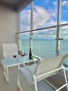 a table and two glasses of wine on a balcony at Raviens Maison de Hotel in Busan