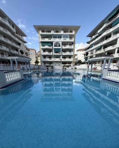 una piscina frente a dos edificios de apartamentos en La Mata Studio TORREVIEJA, en La Mata