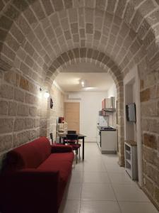 un soggiorno con divano rosso e muro di mattoni di Tofus antiqua a Trapani