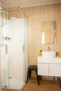 a bathroom with a sink and a glass shower at La Cabane de Camille in Pithon