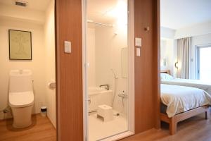 a bathroom with a toilet and a bed and a shower at Yolo Hotel in Tokyo +24 photos