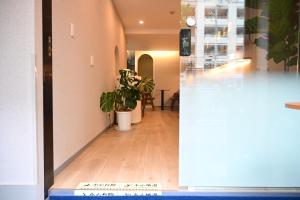 a hallway with a potted plant in a building at Yolo Hotel in Tokyo
