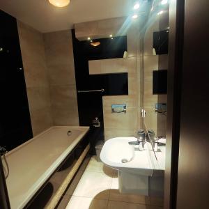 a bathroom with a tub and a sink and a bath tub at Gościniec Tenczyn in Tenczyn