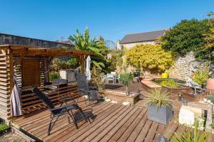 a patio with chairs and a wooden deck at Gite de la ferme du château 1 - Appt climatisé in Denezé-sous-Doué