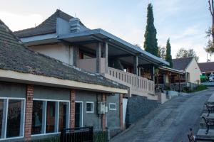 an old house with a porch on a street at Cemara Indah Hotel in Bromo