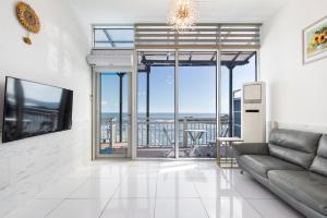 a living room with a couch and a view of the ocean at Yeongdeok Searest Pool Villa in Changsa-ri +13 photos