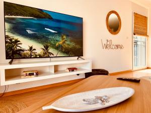 a living room with a large flat screen tv on a wall at Loft Cosy sur le Lac in Bouveret