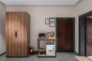 Sulţānahにあるالاورفلي للوحدات السكنيةのドア、テーブル、電子レンジが備わる客室です。