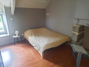 een kleine kamer met een bed en een tafel. bij Spacieuse maison avec piscine in Plédran