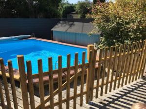 een houten hek naast een zwembad bij Spacieuse maison avec piscine in Plédran +16 foto's