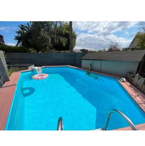 een groot blauw zwembad in een achtertuin bij Spacieuse maison avec piscine in Plédran